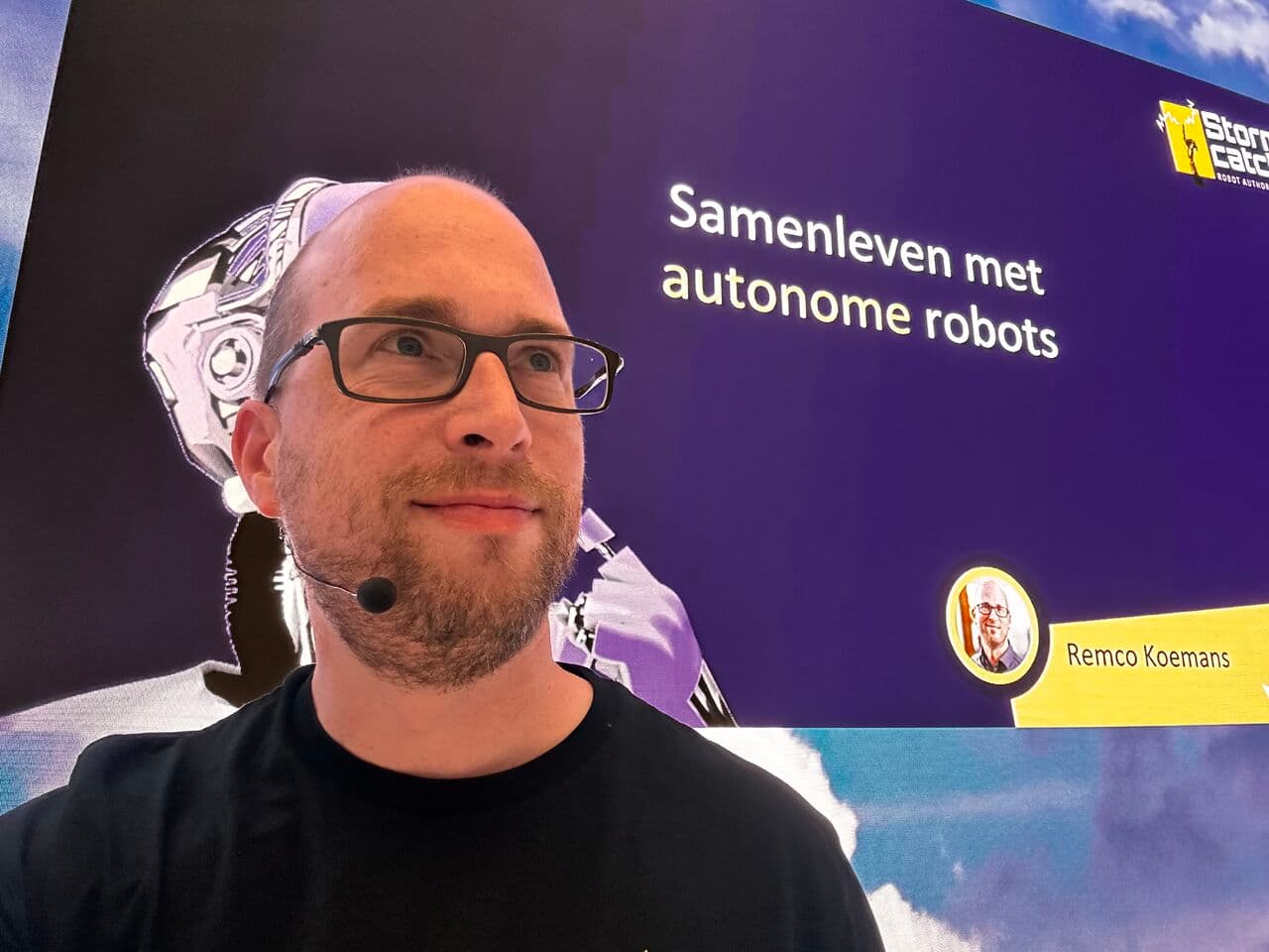 Spreker met headset voor een presentatieslide met de tekst 'Samenleven met autonome robots'